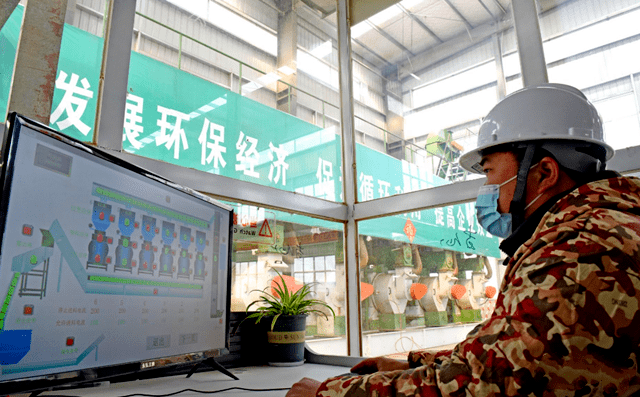 淮南市壽縣一家顆粒廠工人正在操控秸稈顆粒機(jī)械設(shè)備加工秸稈，生產(chǎn)生物燃料